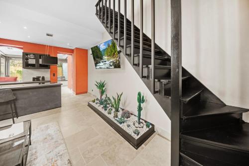 a kitchen and living room with a staircase with plants at Maison d'architecte avec Jacuzzi, Quartier Prémontrés in Pont-à-Mousson