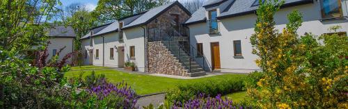 a house with a garden with flowers in front of it at Oldwalls Gower in Llanrhidian