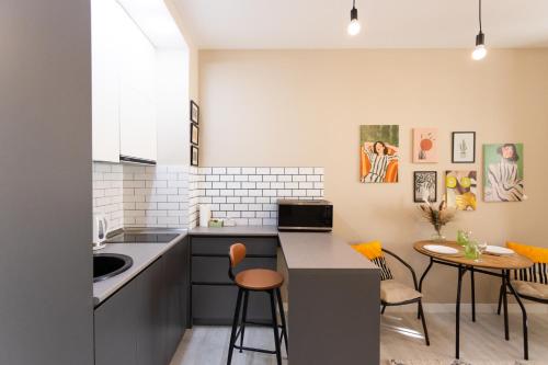 a kitchen with a counter and a table and chairs at Boho apartment studio in Batumi