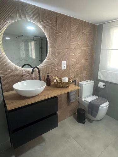 a bathroom with a sink and a mirror and a toilet at LM apartamentos Alfacar in Alfacar