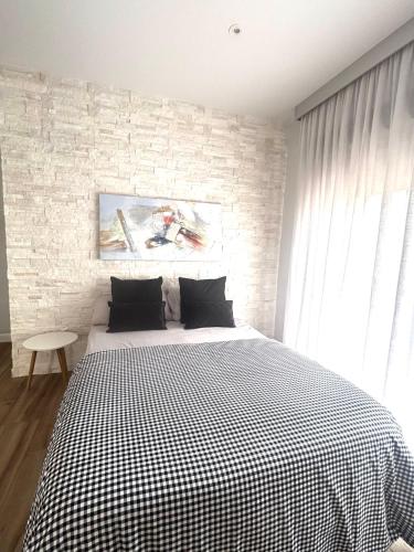 a bedroom with a bed with a black and white checkered blanket at LM apartamentos Alfacar in Alfacar