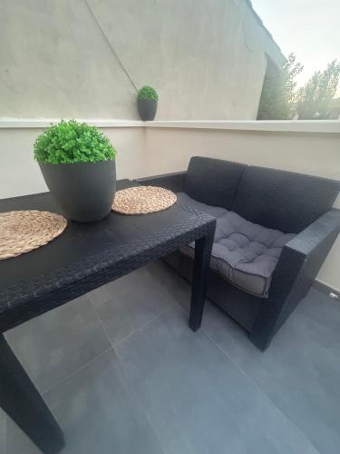a black couch and a table with a potted plant at LM apartamentos Alfacar in Alfacar