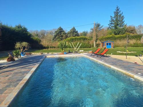 a large swimming pool with two chairs in a yard at Villa Lailléa in Laillé