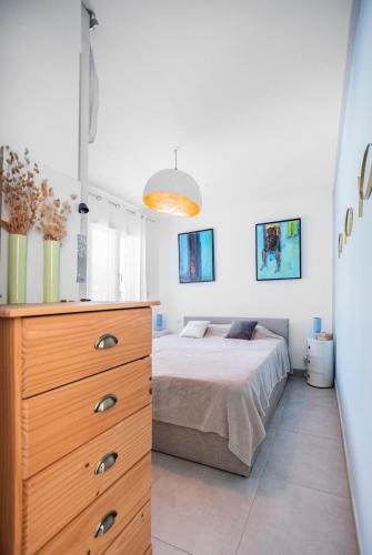 une chambre avec un lit et une commode en bois dans l'établissement Casa Olâ House, à Luri