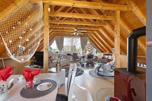 a living room with a table and chairs and a ceiling at Ferienhaus Harmonie in Südbrookmerland