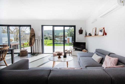 una sala de estar con un sofá y una mesa en Casa Olâ House, en Luri