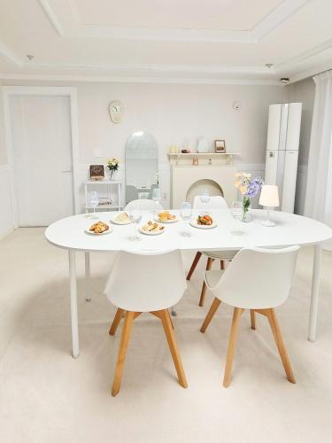 a white dining room with a white table and chairs at StayHo in Daejeon