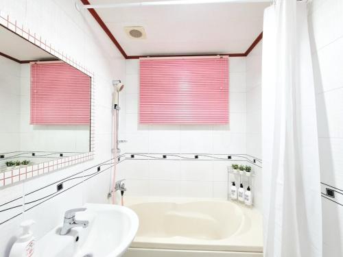 a white bathroom with a tub and a sink at StayHo in Daejeon