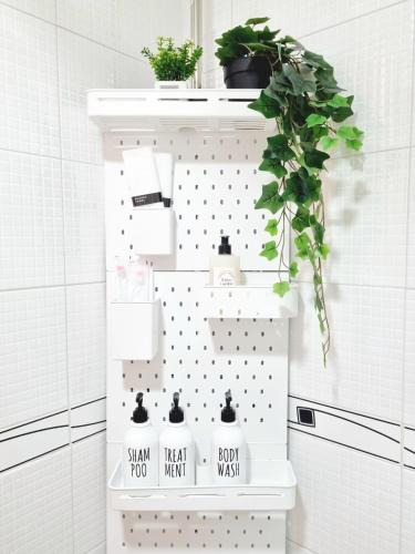 a shelf in a bathroom with white tiles at StayHo in Daejeon