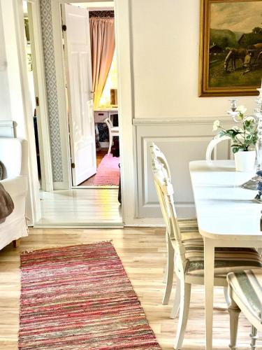 a white dining room with a white table and chairs at Fairy Lake Retreat! Uniquely Located House with Dock! in Bålsta