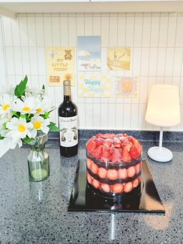 a bottle of wine and a cake and a bottle of strawberries at StayHo in Daejeon