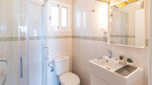 a bathroom with a toilet and a sink and a shower at Casa Candiles Torrox by Ruralidays in Torrox