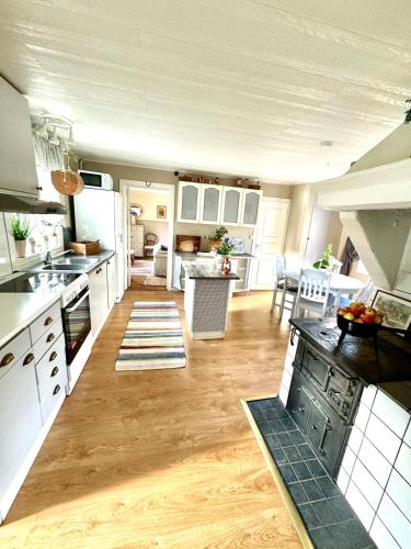 a large kitchen with white cabinets and a table at Fairy Lake Retreat! Uniquely Located House with Dock! in Bålsta