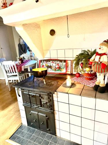 a toy kitchen with a stove and a snowman on the counter at Fairy Lake Retreat! Uniquely Located House with Dock! in Bålsta