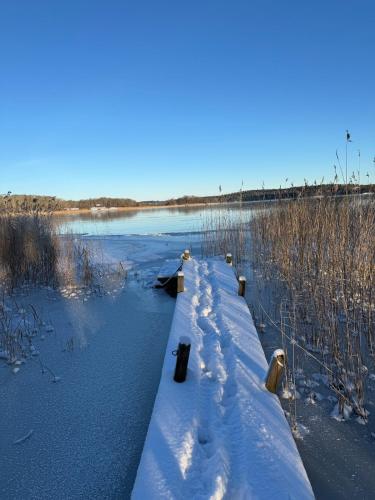 a walkway over a river with snow on it at Fairy Lake Retreat! Uniquely Located House with Dock! in Bålsta