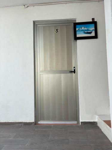 a door to a white building with a sign on it at Condohotel Mictlan Akumal in Akumal