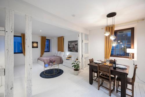 Cette chambre blanche comprend un bureau, un lit et une table. dans l'établissement Petit chateau 1L, à Dettwiller