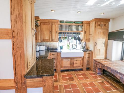 a kitchen with wooden cabinets and a sink at Wyre Court Cottage in Bewdley