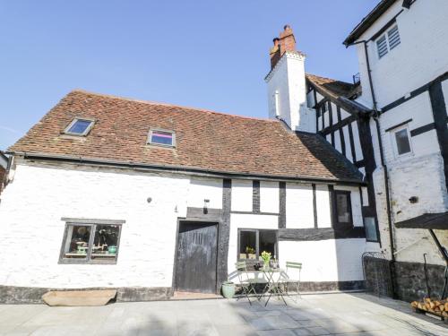 an old white building with a brown roof at Wyre Court Cottage in Bewdley