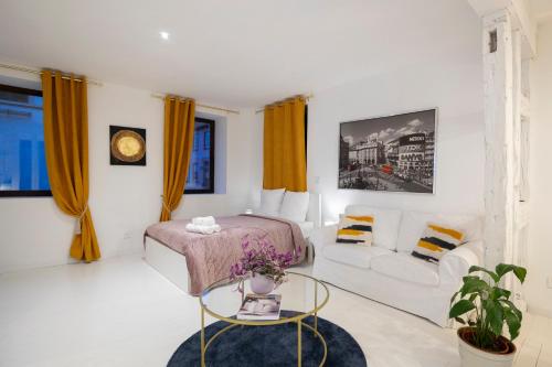 - une chambre blanche avec un lit et un canapé dans l'établissement Petit chateau 1L, à Dettwiller