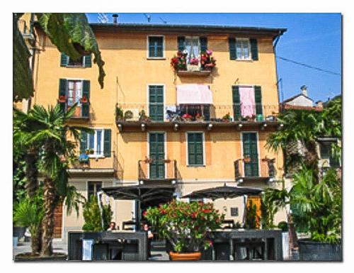 un gran edificio con flores delante en Piazzetta Lago, en Cannobio
