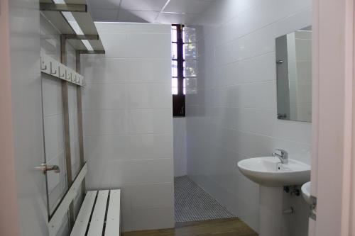 a white bathroom with a sink and a mirror at Pórtico del Azahín in Cazalla de la Sierra