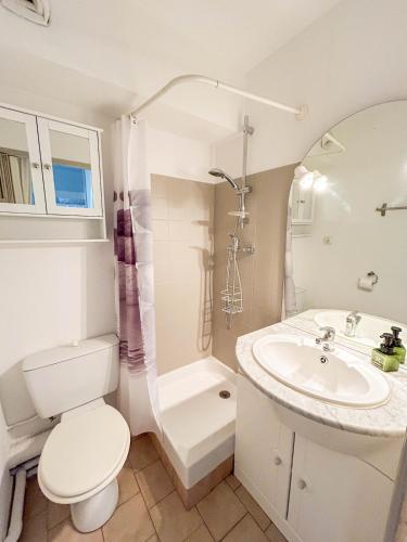 une salle de bain blanche avec des toilettes et un lavabo dans l'établissement Studio en rez-de-jardin à Bandol - parking, à Bandol