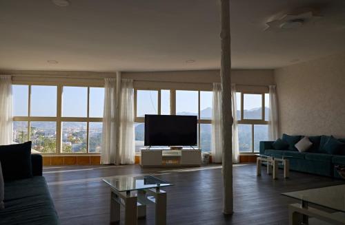 a living room with a couch and a flat screen tv at Mountain Zen 2 Bed Ultimate Retreat with BBQ & Pool in Masāfī