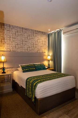 a bedroom with a large bed and two lamps at Corazón Del Café Hotel Boutique in Comitán