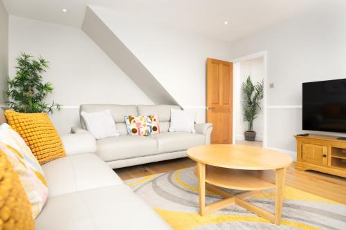 a living room with a white couch and a table at Sillwood Mews - With Free Parking in Brighton & Hove