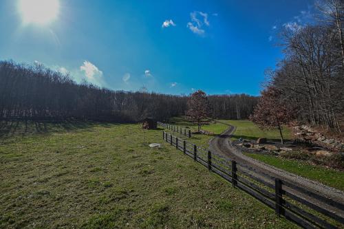 a fence in a field next to a road at Couples Retreat - The HayLoft- Rustic Escape For 2 in Oakland