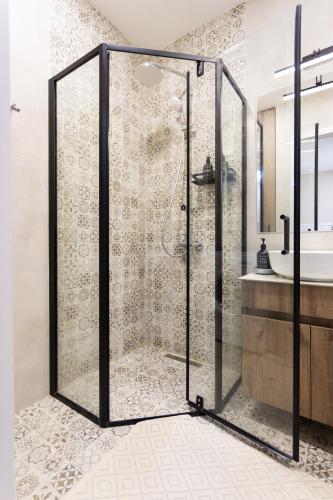 a shower with a glass door in a bathroom at Boho apartment studio in Batumi