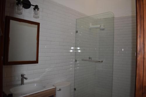 a bathroom with a sink and a glass shower at Suite de lujo en finca de café in Antigua Guatemala