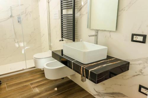 a white bathroom with a sink and a toilet at Villa Le Chianche in Vico del Gargano