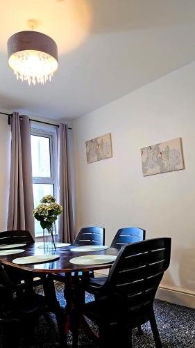 a dining room table with chairs and a chandelier at IVY GREEN HOUSE - STYLISH VALUE STAY, SLEEPS upto 7, LUXURY BEDS, CENTRAL, WIFI, NETFLIX, FREE PARKING in Derby