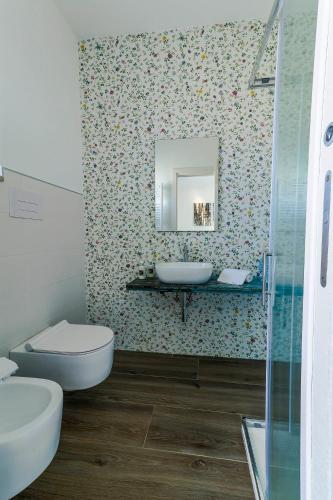 a bathroom with a toilet and a sink and a mirror at Villa Le Chianche in Vico del Gargano