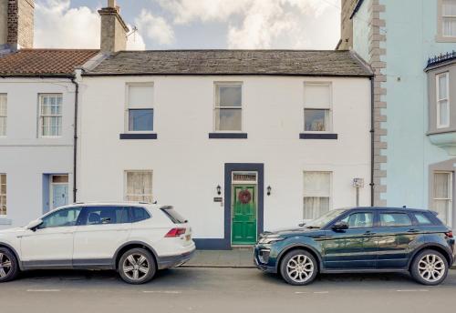 two cars parked in front of a white house at NEW The Procession Grade II Listed and Pet Friendly in Berwick-Upon-Tweed
