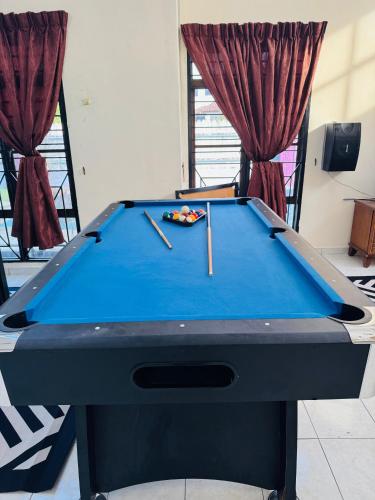 a pool table with two cuesticks on top of it at Private Villa With pool bbq sound system wifi snooker in Kampong Balik Mungkar