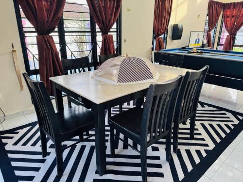a dining room table and chairs in a room at Private Villa With pool bbq sound system wifi snooker in Kampong Balik Mungkar