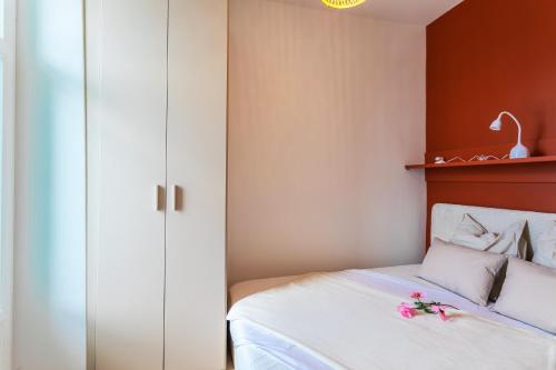 - une chambre dotée d'un lit avec des draps blancs et des murs rouges dans l'établissement TERRACOTTA AP4457 By Riviera Holiday Homes, à Villefranche-sur-Mer