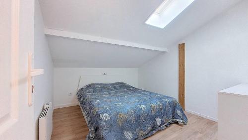 une chambre avec un lit dans une pièce blanche dans l'établissement V- Landes 08-Vieux Boucau Appartement 3 pièces pour 4 personnes dans une résidence au bord du lac marin, à Vieux-Boucau-les-Bains