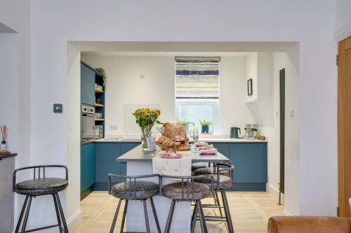 a kitchen with blue cabinets and a table with chairs at NEW The Procession Grade II Listed and Pet Friendly in Berwick-Upon-Tweed