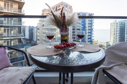 a table with two glasses of wine on a balcony at Boho apartment studio in Batumi
