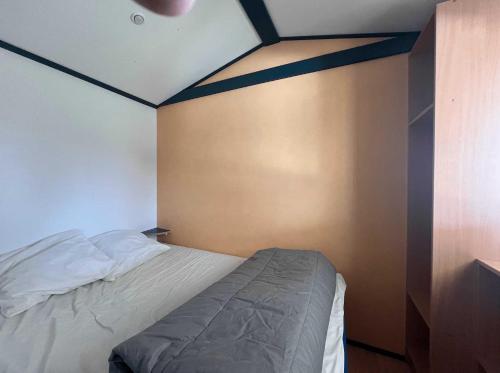 a bedroom with a bed in the corner of a room at Camping 3 étoiles - efaicg in Auxonne