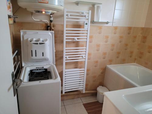 une petite cuisine avec un réfrigérateur et un évier dans l'établissement Les Genêts, à Saint-Jean-de-Monts