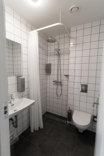 a bathroom with a shower and a toilet and a sink at Roberta's Society Aarhus in Aarhus