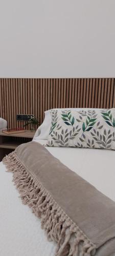 a bed with a blanket and pillows on it at PILGRIMSROOM la Parada Del Camino in Negreira