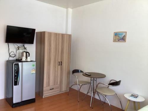 a room with a refrigerator and a table and chairs at mom's home in Phuket