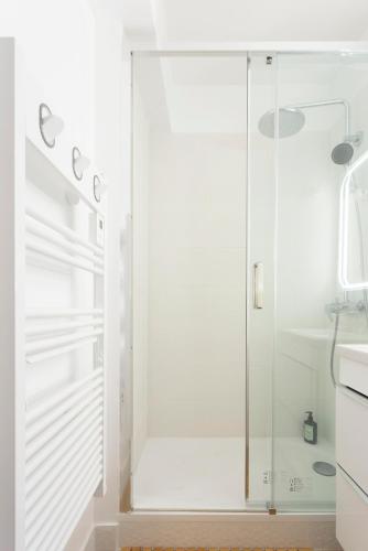 une douche avec une porte vitrée dans une salle de bain dans l'établissement Chez Françoise Fr - Spacieux appartement vue imprenable avec ascenseur, à La Grande Motte