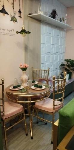 a table and chairs with plates and flowers on it at Kasara Serenity Condotel in Manila